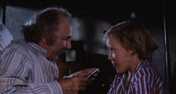 Movie still from “Willy Wonka & the Chocolate Factory” (1971), directed by Mel Stuart – An older man and a young girl looking at a cell phone; Close Up shot, Low angle