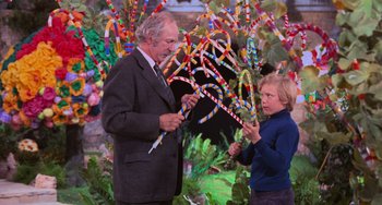 Movie still from “Willy Wonka & the Chocolate Factory” (1971), directed by Mel Stuart – An older man and a young boy looking at candy canes; Medium shot, Over the shoulder angle
