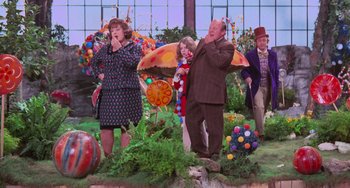 Movie still from “Willy Wonka & the Chocolate Factory” (1971), directed by Mel Stuart – A group of people standing in a field holding umbrellas; Wide shot, High angle