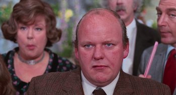 Movie still from “Willy Wonka & the Chocolate Factory” (1971), directed by Mel Stuart – A man with a frowning look on his face; Close Up shot, Over the shoulder angle