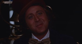 Movie still from “Willy Wonka & the Chocolate Factory” (1971), directed by Mel Stuart – A person wearing a suit and a bow tie; Close Up shot, Over the shoulder angle