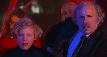 Movie still from “Willy Wonka & the Chocolate Factory” (1971), directed by Mel Stuart – A man and a boy in a dark room; Close Up shot, Low angle