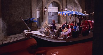 Movie still from “Willy Wonka & the Chocolate Factory” (1971), directed by Mel Stuart – A group of people riding a boat on a body of water; Extreme Wide shot, High angle