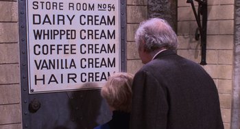 Movie still from “Willy Wonka & the Chocolate Factory” (1971), directed by Mel Stuart – A couple of people standing in front of a sign; Extreme Close Up shot, High angle