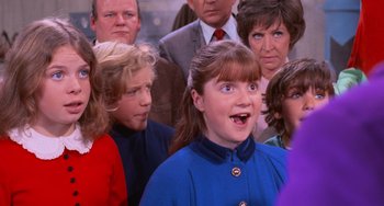 Movie still from “Willy Wonka & the Chocolate Factory” (1971), directed by Mel Stuart – A group of people standing in a room; Close Up shot, Over the shoulder angle