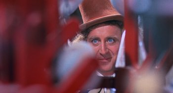 Movie still from “Willy Wonka & the Chocolate Factory” (1971), directed by Mel Stuart – A person wearing a hat and looking at the camera; Close Up shot, Over the shoulder angle