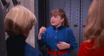 Movie still from “Willy Wonka & the Chocolate Factory” (1971), directed by Mel Stuart – A woman in a blue dress talking to another woman; Medium shot, Over the shoulder angle