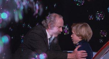 Movie still from “Willy Wonka & the Chocolate Factory” (1971), directed by Mel Stuart – An older man and a young boy playing with soap bubbles; Medium shot, Over the shoulder angle