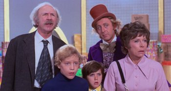 Movie still from “Willy Wonka & the Chocolate Factory” (1971), directed by Mel Stuart – A group of people standing next to each other in a room; Medium shot, Low angle