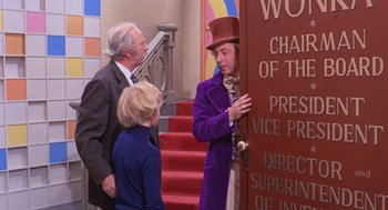 Movie still from “Willy Wonka & the Chocolate Factory” (1971), directed by Mel Stuart – A group of people standing next to each other near a building; Medium shot, Over the shoulder angle