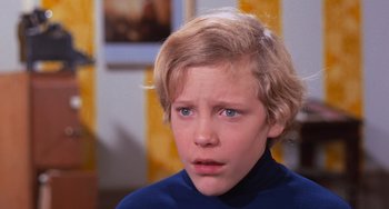 Movie still from “Willy Wonka & the Chocolate Factory” (1971), directed by Mel Stuart – A young boy with blonde hair and blue eyes looking sad; Close Up shot, High angle