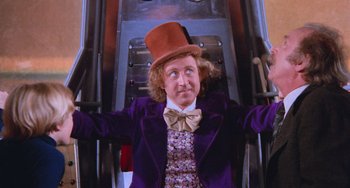 Movie still from “Willy Wonka & the Chocolate Factory” (1971), directed by Mel Stuart – Willy wonka in a purple jacket and a brown top hat; Medium shot, Low angle