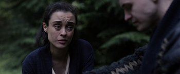 Movie still from “Winnie the Pooh: Blood and Honey” (2023), directed by Rhys Frake-Waterfield – A woman sitting in front of a man in the woods; Close Up shot, Over the shoulder angle