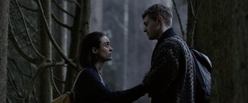 Movie still from “Winnie the Pooh: Blood and Honey” (2023), directed by Rhys Frake-Waterfield – A man and a woman standing next to each other in the woods; Medium shot, Low angle