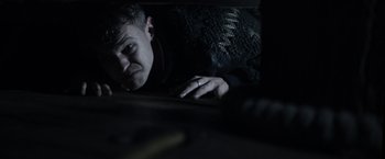 Movie still from “Winnie the Pooh: Blood and Honey” (2023), directed by Rhys Frake-Waterfield – A man with a wedding ring is laying in a dark room; Close Up shot, High angle