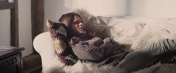 Movie still from “Winnie the Pooh: Blood and Honey” (2023), directed by Rhys Frake-Waterfield – A woman laying in a chair with a dog; Medium shot, High angle