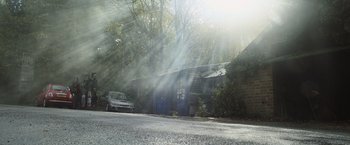 Movie still from “Winnie the Pooh: Blood and Honey” (2023), directed by Rhys Frake-Waterfield – A car parked in front of an abandoned building; Extreme Wide shot, Low angle