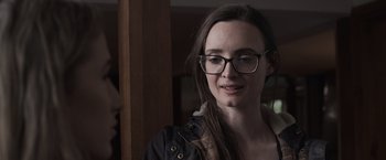 Movie still from “Winnie the Pooh: Blood and Honey” (2023), directed by Rhys Frake-Waterfield – A woman wearing glasses looking at the camera; Close Up shot, Over the shoulder angle