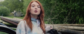 Movie still from “Winnie the Pooh: Blood and Honey” (2023), directed by Rhys Frake-Waterfield – A beautiful young woman with long red hair holding a purse; Close Up shot, Over the shoulder angle