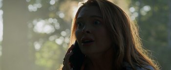 Movie still from “Winnie the Pooh: Blood and Honey” (2023), directed by Rhys Frake-Waterfield – A young woman talking on a cell phone outside; Close Up shot, Low angle