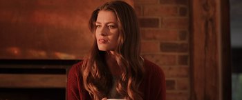 Movie still from “Winnie the Pooh: Blood and Honey” (2023), directed by Rhys Frake-Waterfield – A beautiful young lady with long brown hair wearing a red sweater; Close Up shot, Low angle