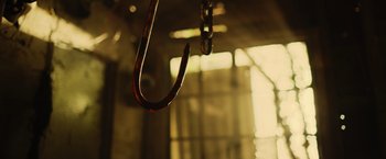 Movie still from “Winnie the Pooh: Blood and Honey” (2023), directed by Rhys Frake-Waterfield – An upside - down hook hanging from a chain in a room; Extreme Close Up shot, Low angle