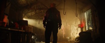Movie still from “Winnie the Pooh: Blood and Honey” (2023), directed by Rhys Frake-Waterfield – A man standing in a room with a lot of smoke coming out of the ceiling; Medium shot, Low angle