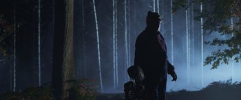 Movie still from “Winnie the Pooh: Blood and Honey” (2023), directed by Rhys Frake-Waterfield – A man and a little girl walking through a forest; Medium shot, Low angle