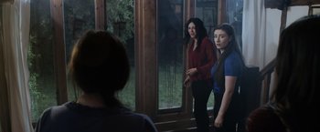 Movie still from “Winnie the Pooh: Blood and Honey” (2023), directed by Rhys Frake-Waterfield – A group of people standing in front of a window; Medium shot, Over the shoulder angle