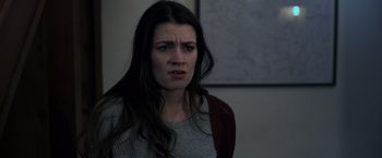 Movie still from “Winnie the Pooh: Blood and Honey” (2023), directed by Rhys Frake-Waterfield – A woman with long dark brown hair is looking at the camera; Close Up shot, Over the shoulder angle