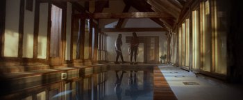 Movie still from “Winnie the Pooh: Blood and Honey” (2023), directed by Rhys Frake-Waterfield – Two people standing next to an indoor swimming pool; Extreme Wide shot, High angle