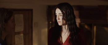 Movie still from “Winnie the Pooh: Blood and Honey” (2023), directed by Rhys Frake-Waterfield – A woman with long black hair is looking to her left; Close Up shot, Over the shoulder angle