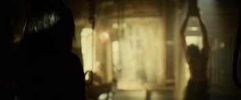 Movie still from “Winnie the Pooh: Blood and Honey” (2023), directed by Rhys Frake-Waterfield – A woman standing in a room with a blurry background; Close Up shot, Over the shoulder angle