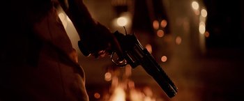 Movie still from “Winnie the Pooh: Blood and Honey” (2023), directed by Rhys Frake-Waterfield – A person holding a gun in their hand in front of lights; Extreme Close Up shot, Low angle