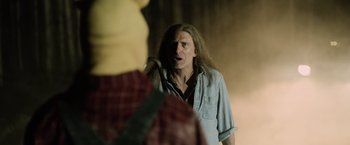 Movie still from “Winnie the Pooh: Blood and Honey” (2023), directed by Rhys Frake-Waterfield – A man with long white hair and a long beard is holding a cane; Close Up shot, Over the shoulder angle