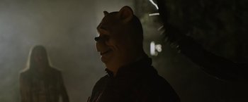 Movie still from “Winnie the Pooh: Blood and Honey” (2023), directed by Rhys Frake-Waterfield – A man wearing a bear mask in the dark; Close Up shot, Over the shoulder angle