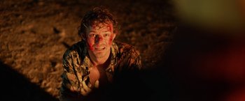 Movie still from “Winnie the Pooh: Blood and Honey” (2023), directed by Rhys Frake-Waterfield – A man with red paint on his face; Close Up shot, Over the shoulder angle