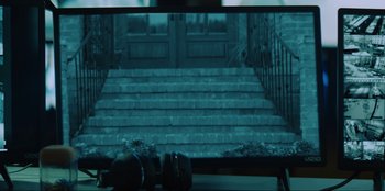 Movie still from “Wire Room” (2022), directed by Matt Eskandari – A television screen with a picture of stairs on it; Extreme Close Up shot, High angle