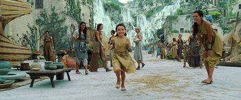 Movie still from “Wonder Woman” (2017), directed by Patty Jenkins – A girl running in front of a waterfall; Wide shot, High angle