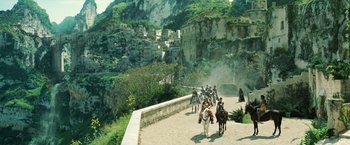Movie still from “Wonder Woman” (2017), directed by Patty Jenkins – A group of people riding horses down a road; Extreme Wide shot, High angle