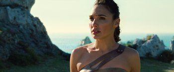 Movie still from “Wonder Woman” (2017), directed by Patty Jenkins – A beautiful woman with brown hair wearing a brown dress; Close Up shot, Over the shoulder angle