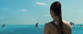 Movie still from “Wonder Woman” (2017), directed by Patty Jenkins – A woman looking out over the ocean at a rock; Close Up shot, Over the shoulder angle
