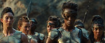 Movie still from “Wonder Woman” (2017), directed by Patty Jenkins – A group of women in gold armor standing next to each other; Close Up shot, Over the shoulder angle