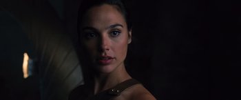 Movie still from “Wonder Woman” (2017), directed by Patty Jenkins – A person wearing a dress and looking at the camera; Close Up shot, Over the shoulder angle