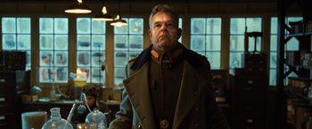 Movie still from “Wonder Woman” (2017), directed by Patty Jenkins – An older man in a military uniform stands in front of a window; Medium shot, Low angle