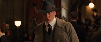 Movie still from “Wonder Woman” (2017), directed by Patty Jenkins – A man wearing a hat and a suit and tie; Close Up shot, Low angle