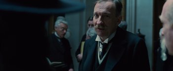 Movie still from “Wonder Woman” (2017), directed by Patty Jenkins – An older man in a suit and a tie; Close Up shot, Low angle