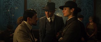 Movie still from “Wonder Woman” (2017), directed by Patty Jenkins – A group of men standing next to each other wearing hats; Medium shot, Over the shoulder angle