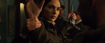 Movie still from “Wonder Woman” (2017), directed by Patty Jenkins – A woman holding a gun in her hands; Close Up shot, Over the shoulder angle