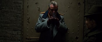 Movie still from “Wonder Woman” (2017), directed by Patty Jenkins – A man in a military uniform blowing smoke from his mouth; Medium shot, Low angle